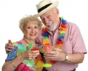 An attractive senior couple on vacation drinking tropical drinks with little umbrellas.  Isolated.